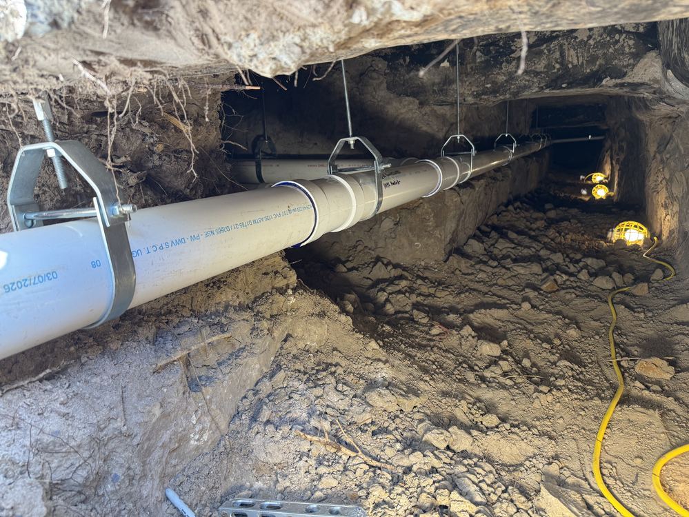 Tunnel excavation with new PVC sewer line properly supported